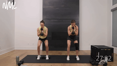 two women performing heel elevated goblet squats under triple tension in a quads and glutes workout