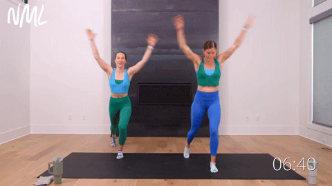 two women performing a single leg high knee jack and tap in a quick ab workout
