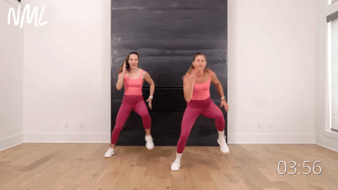 two women performing lateral heisman runners in an indoor walking workout