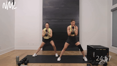 two women performing heel elevated lateral squats in a quad and glute workout at home