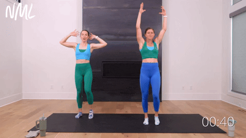 two women performing an opposite hand to toe touch in an ab workout for women