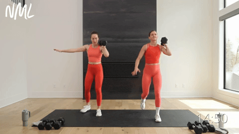 two women performing a dumbbell snatch and split lunge in a muscle building workout