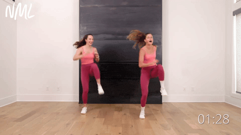 two women doing a knee to elbow tap in an indoor walking and steps workout