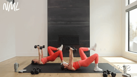 two women performing a glute bridge and skull crushers in a muscle building workout
