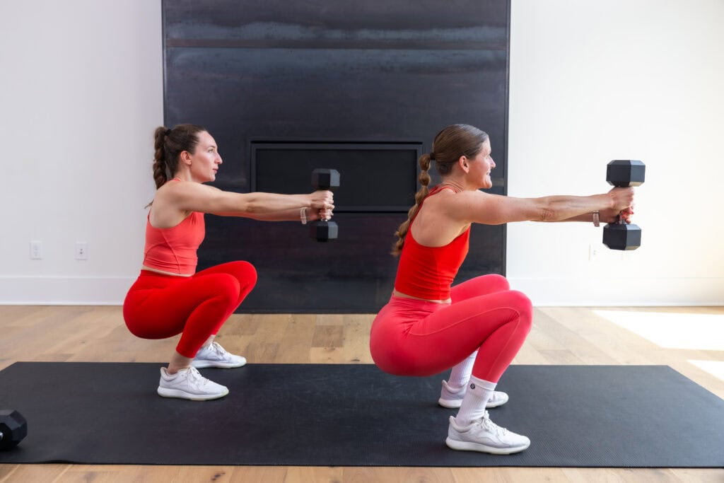 two women performing a kang squat and swing in a muscle building workout