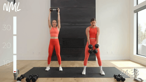 two women performing a dumbbell burpee in a muscle building workout