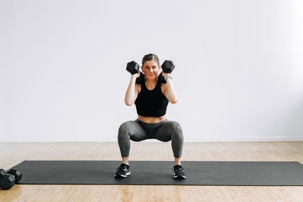 Woman performing a Clean Squat with Dumbbells | back and biceps workout