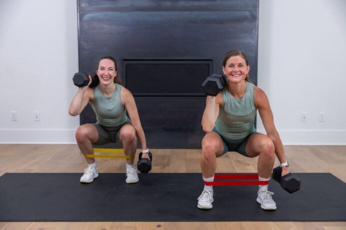 two women performing a uneven squat thruster